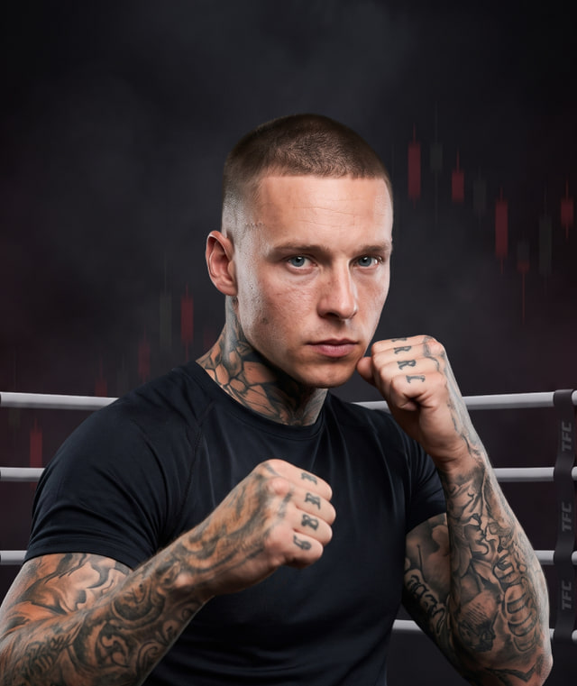 Adrian Mudronja in a guard stance in a TFC ring, arms tattooed